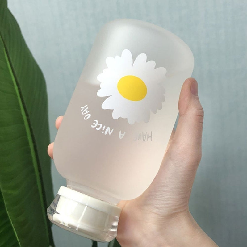Gourde en verre avec paille posée sur une table