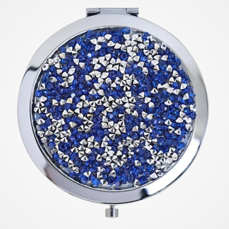 Miroir de poche avec strass posé sur une table
