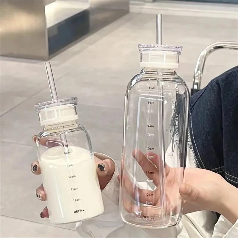 Bouteille en verre avec paille tenue en main