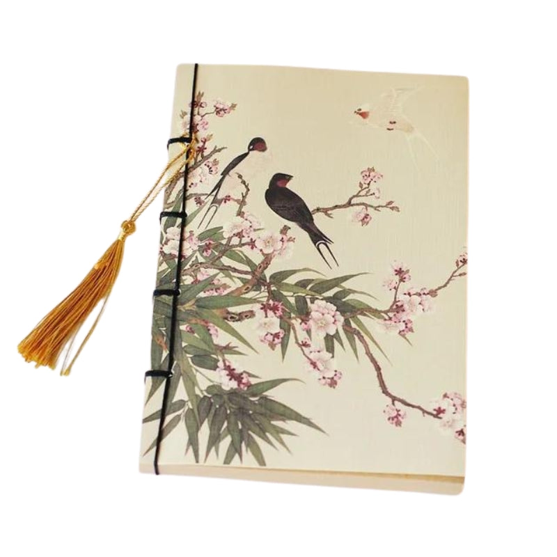 Carnet de voyage à motif oiseau posé sur une table