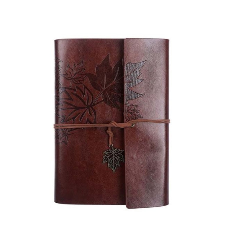 Carnet de voyage vintage posé sur une table en bois