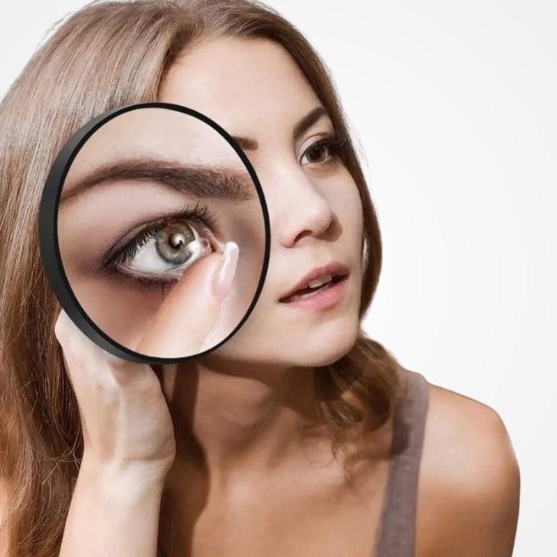 Miroir grossissant tenu en main pour retouche maquillage